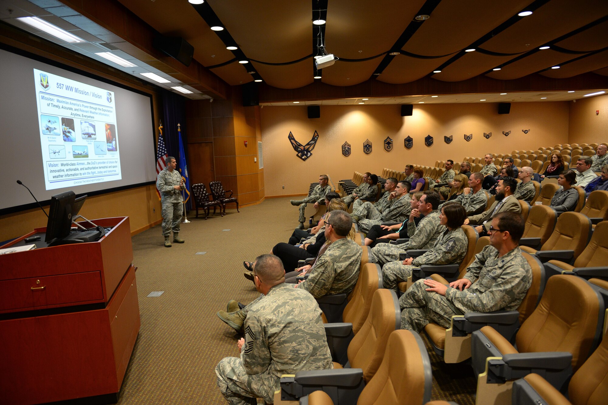 Col. Steven N. Dickerson, commander of the 557th Weather Wing, gives a mission brief to service members and spouses at the Spouses' Event held by the wing at Offutt Air Force Base, Nebraska, Oct. 3, 2017. The event was designed to give spouses a deeper understanding of the weather mission.