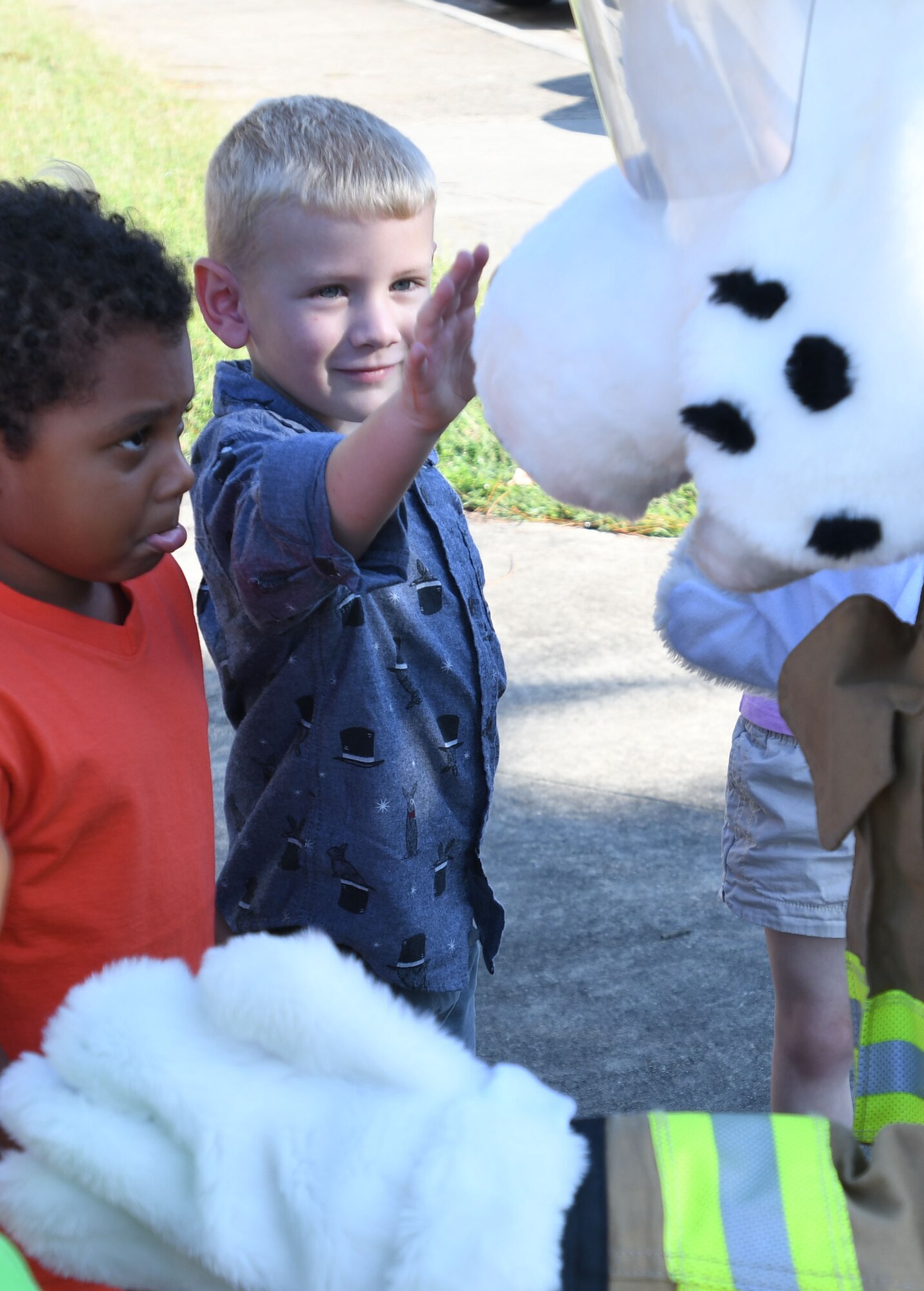 Alexandru Kemayou, son of Airman 1st Class Guy Alein Kemayou, 81st Communications Squadron client systems technician, and Nate Heiney, son of Staff Sgt. Heather Heiney, 403rd Wing public affairs specialist, visit with Sparky the Fire Dog at the Keesler Child Development Center during a Fire Prevention Week demonstration Oct. 11, 2017, on Keesler Air Force Base, Mississippi. The week-long event included fire drills, literature handouts, stove fire demonstrations around the base and concluded with an open house at the fire department. (U.S. Air Force photo by Kemberly Groue)