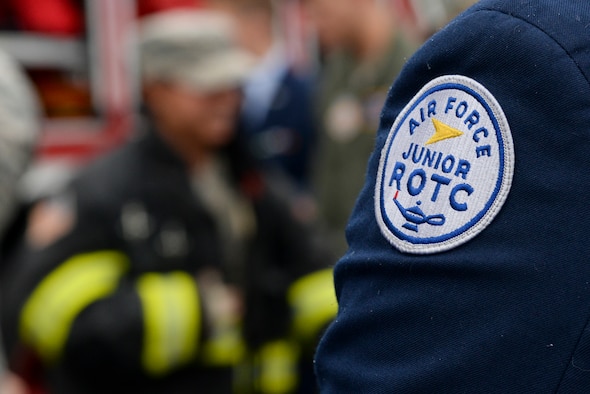 An ROTC cadet tries on bunker gear while a Junior ROTC cadet watches Oct. 11, 2017, during a Pathways to Blue tour at Dover Air Force Base, Del. About 40 local cadets visited the installation to get a better understanding of active duty military service. (U.S. Air Force photo by Staff Sgt. Aaron J. Jenne)