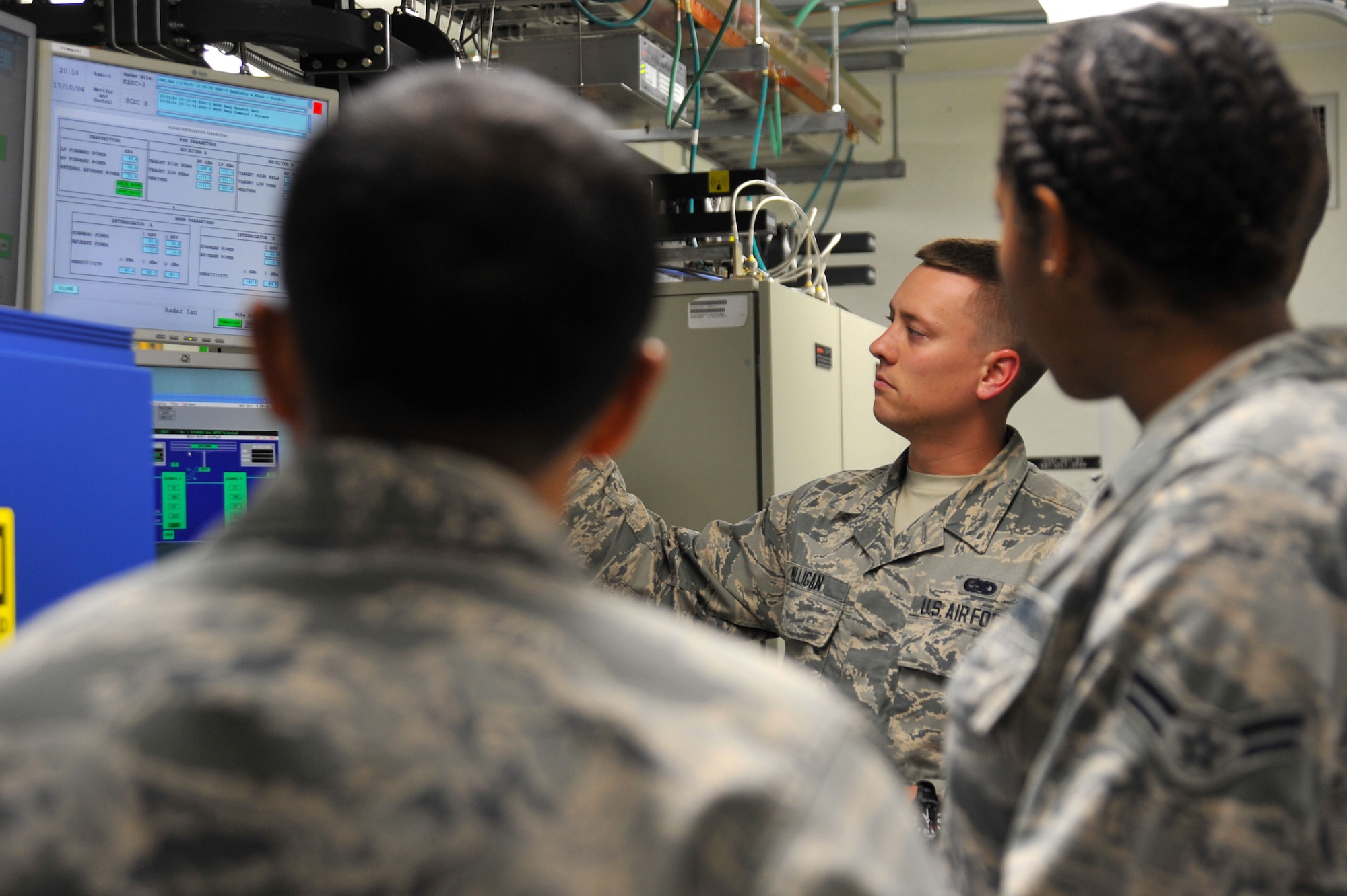 U.S. Air Force Senior Airman Brendan Milligan, 20th Operations Support Squadron (OSS) ground radar systems technician, center, checks radar parameter values at a monitor and a Digital Airport Surveillance Radar control screen as Airman 1st Class Darricka Sides, 20th OSS airfield systems technician, right, and Staff Sgt. Rajiv Shetty, 20th OSS ground radar systems noncommissioned officer in charge, observe at Shaw Air Force Base, S.C., Oct. 4, 2017.