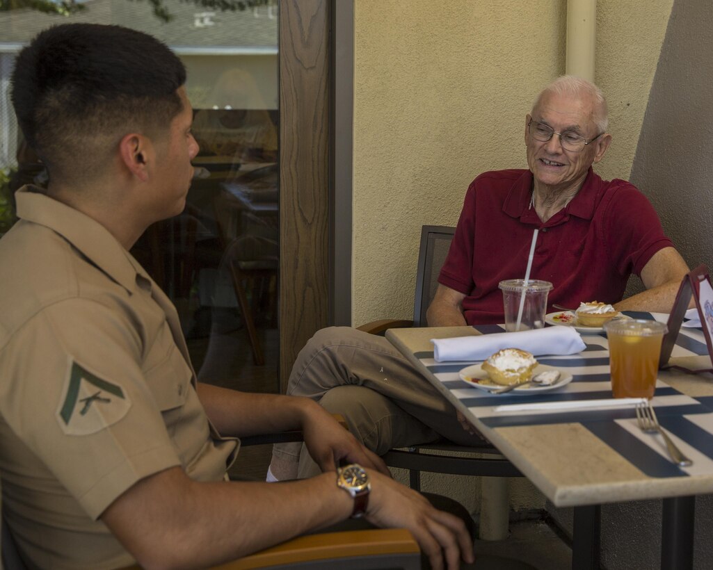 Lance Corporal Samuel Solislopez, a Due and Status File Clerk, I Marine Expeditionary Force Information Group, speaks about his experiences in the Marine Corps over lunch with Bob Casillas, a resident at The Covington, a retirement community in Viejo, Calif., October 4, 2017. This community outreach event also showed military veterans our support and appreciation for the sacrifices they have made.