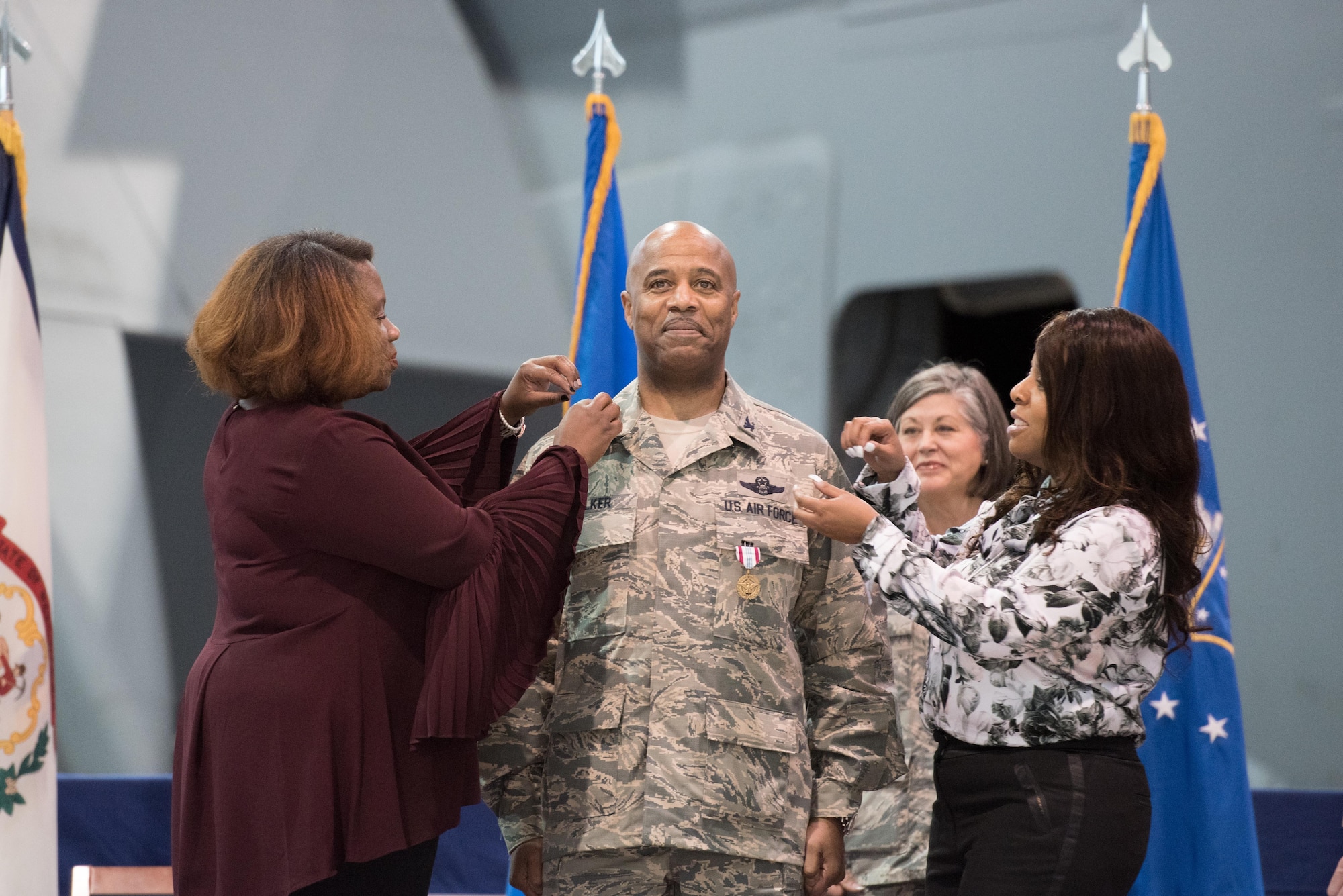 Brig. Gen. Christopher "Mookie" Walker, Chief of Staff for the West Virginia Air National Guard, is pinned during his promotion ceremony by his sister, Nicole Walker, right, and family friend, Regina Evans, left, at the 167th Airlift Wing, Martinsburg, W.Va., Oct 14. (U.S. Air National Guard photo by Staff Sgt. Jodie Witmer)