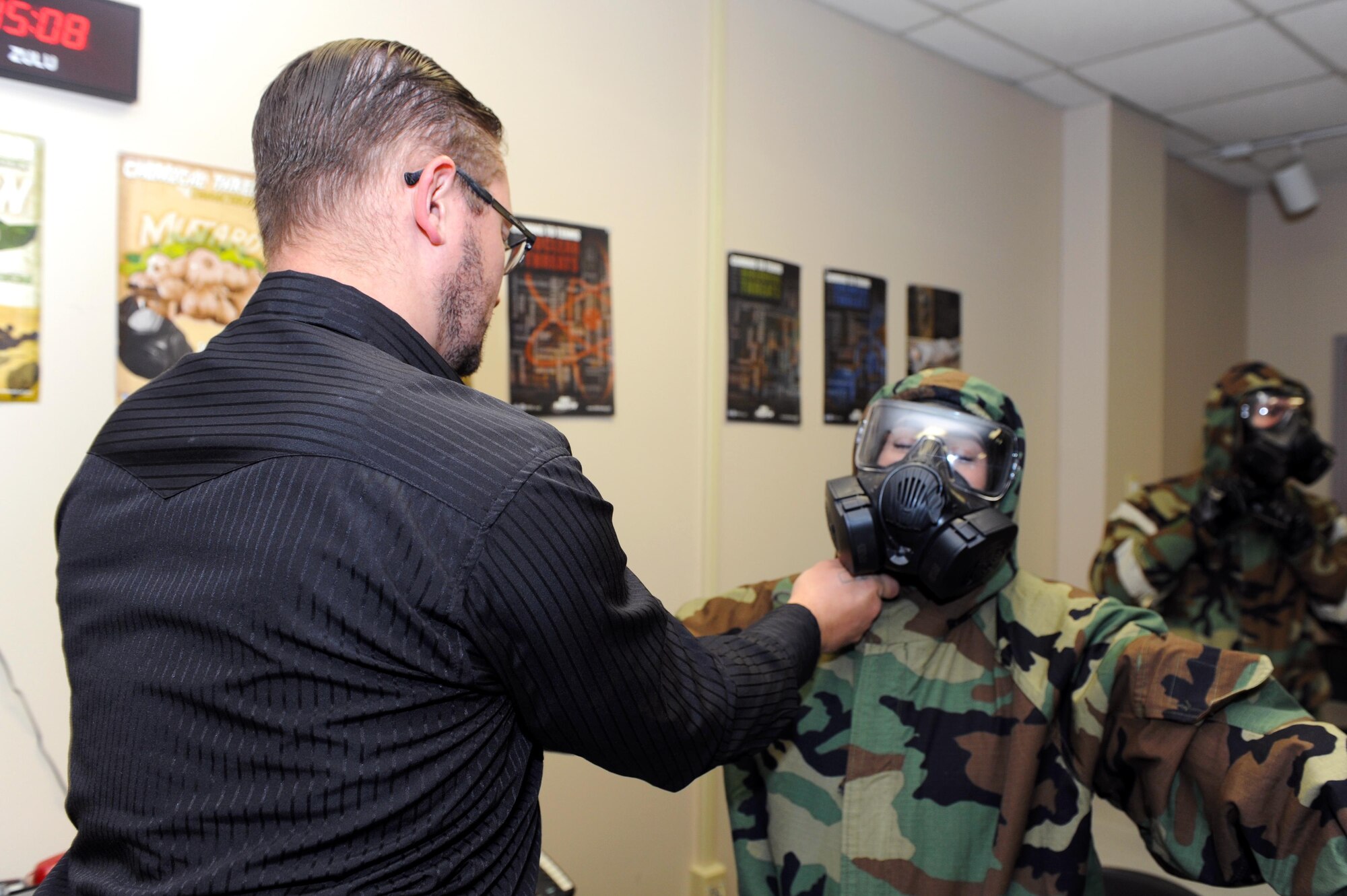 David Shore, 913th Force Support Squadron Chemical, Biological, Radiological, Nuclear and high-yield Explosives training instructor for the 19th Civil Engineer Squadron Readiness and Emergency Management flight, assists a student with her mission-oriented protective posture gear during CBRNE training Oct. 10, 2017, at little Rock Air Force Base, Ark. CBRNE training is intended to prepare Airmen for the possibility of a chemical, biological, radiological or nuclear attack. (U.S. Air Force photo by Airman 1st Class Grace Nichols)