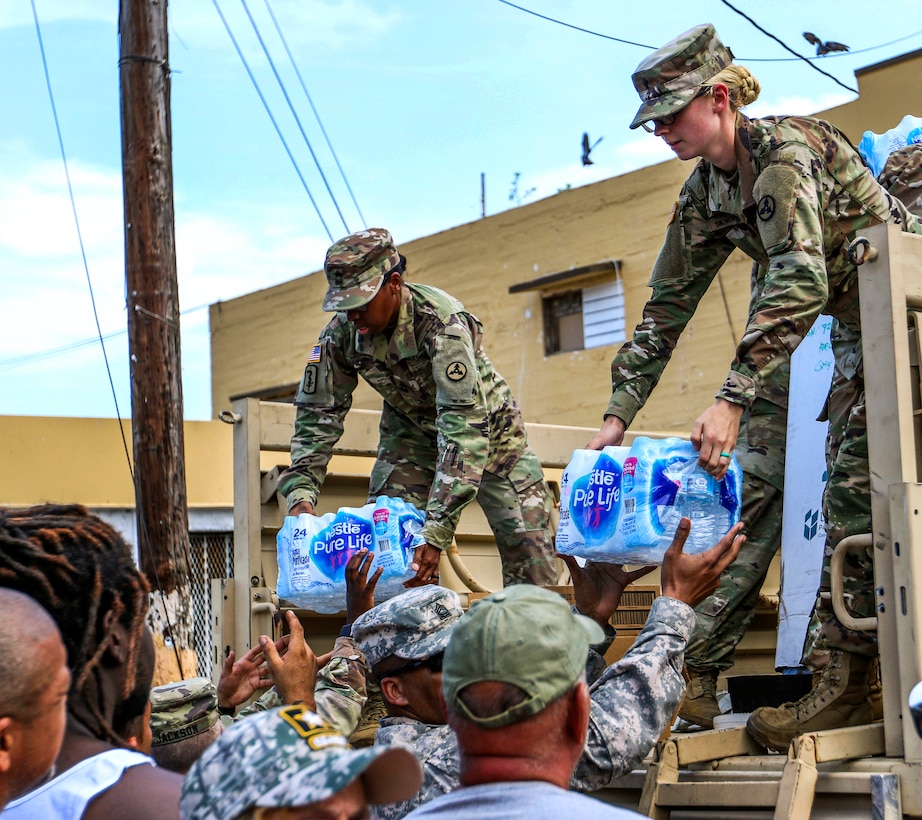 Soldiers unload cases of water for residents in Puerto Rico.