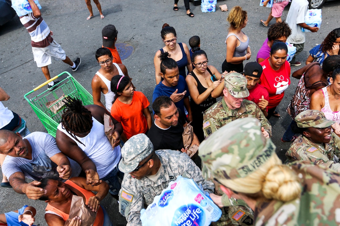Soldiers unload cases of water for residents of Puerto Rico.