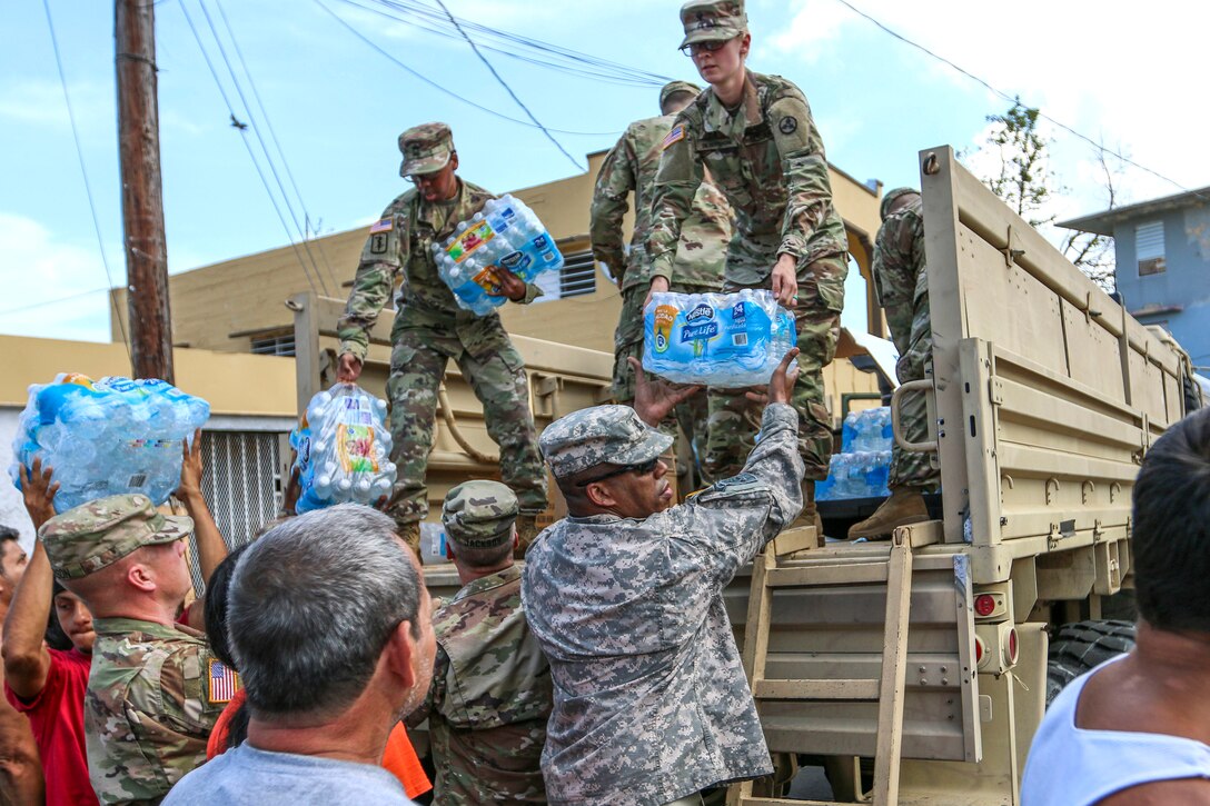 Soldiers deliver cases of bottled water to residents in Puerto Rico.
