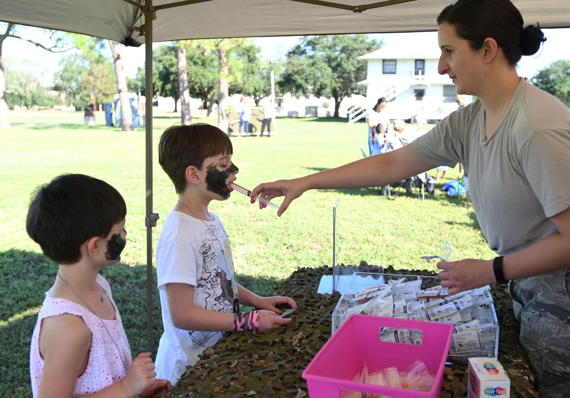 Staff Sgt. Lisa Niehus, 81st Medical Group instructor, administers a shot of punch to her daughters, Maddison and Carlina, during Operation Hero Oct. 14, 2017, on Keesler Air Force Base, Mississippi. The event was designed to help children better understand what their parents do when they deploy. (U.S. Air Force photo by Kemberly Groue)