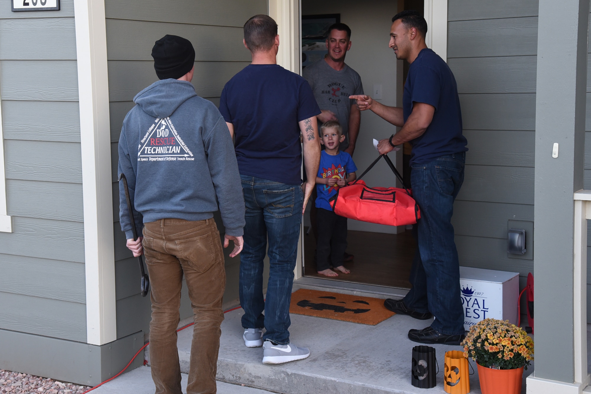 21st Civil Engineer fire fighters deliver pizza to a family at Tierra Vista housing on Peterson Air Force Base, Colorado, Oct. 13, 2017. The pizza was free if the family agreed to a fire inspection of their home. (U.S. Air Force photo by Robb Lingley)