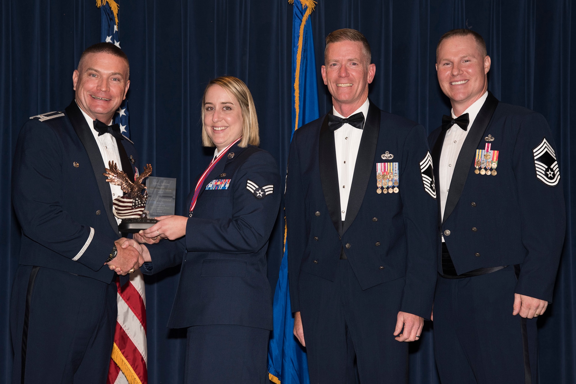 Col. Eric Dorminey, 21st Space Wing vice commander, presents Senior Airman Kayla Drummond, Air Force Technical Applications Center Detachment 46, the John L. Levitow award during the Airmen Leadership School graduation, Oct. 12, 2017, at Peterson Air Force Base, Colorado. The award is presented to the distinguished graduate from each class of the ALS and is named in honor of John L. Levitow, the lowest ranking Airman to ever receive the Medal of Honor. (U.S. Air Force photo by Staff Sgt. Tiffany Lundberg)