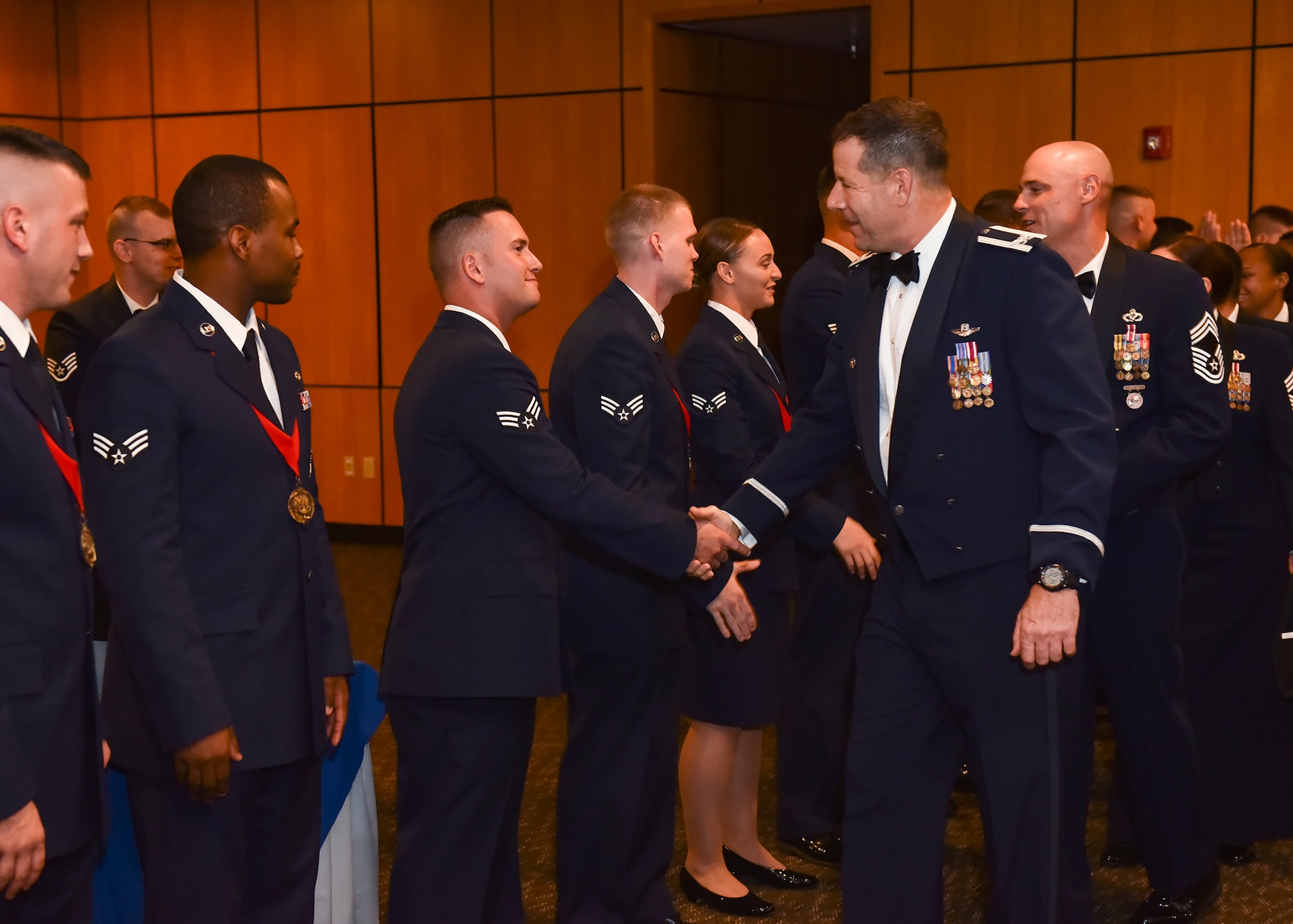Col. Michael Hernandez, 325th Fighter Wing commander, shakes the hand of an Airman Leadership School graduate after the ceremony at Horizons Community Center Oct. 11, 2017.