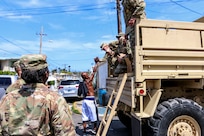 A resident thanks a soldier after he hands out food and water to families.