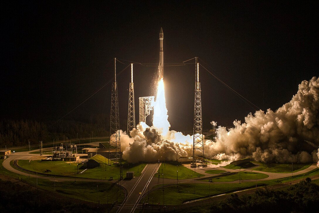 A rocket takes off from a launchpad at night.