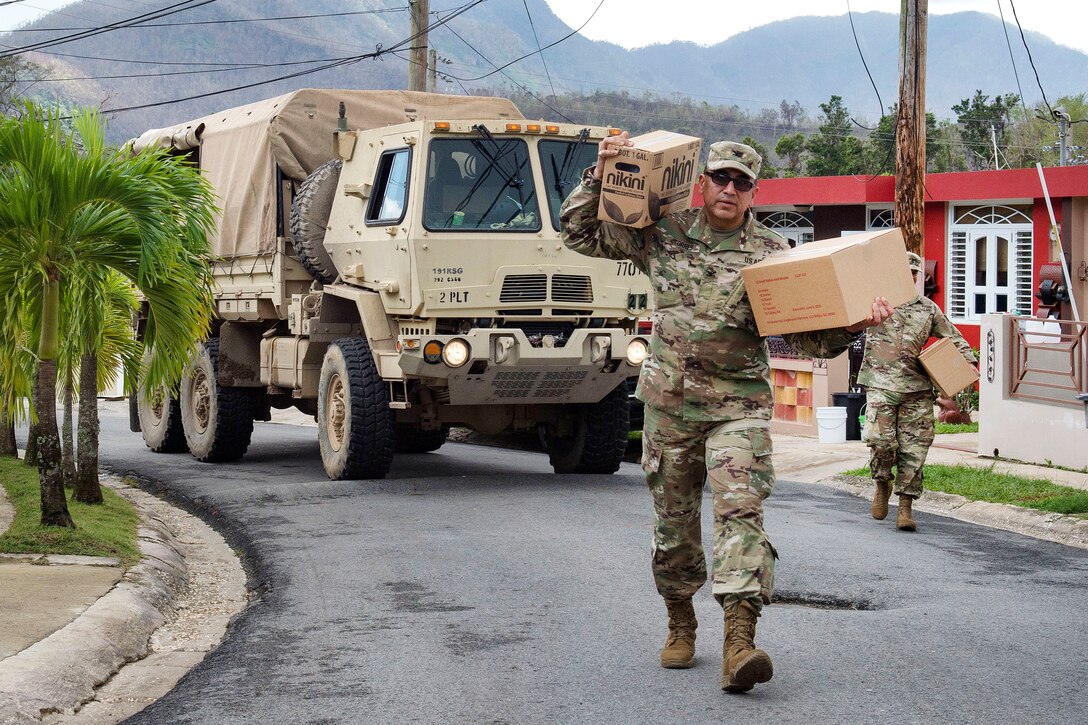 Soldiers and the Puerto Rico National Guardsmen deliver cases of water and shelf-stable meals to residents.
