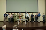 DLA Distribution commander Army Brig. Gen. John S. Laskodi, center, sings the Navy song in honor of the Navy’s 242nd birthday alongside DLA Distribution’s active, reserve and retired Navy sailors.
