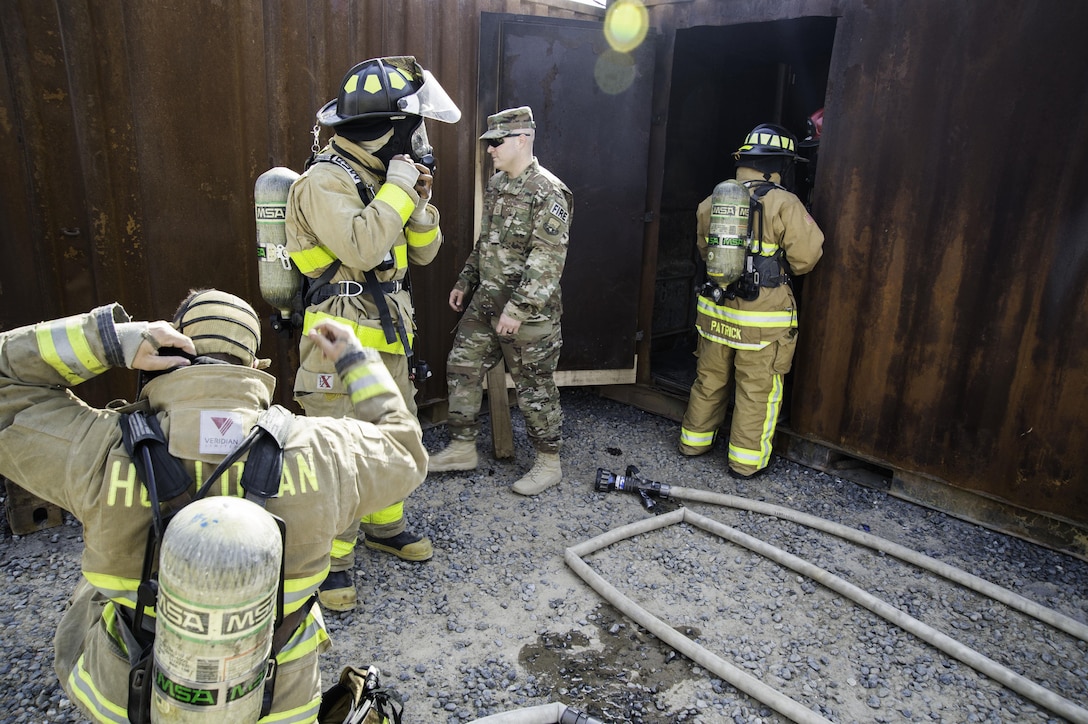 Airmen from the 386th Expeditionary Civil Engineer Squadron Fire Department prepare to enter a live fire training facility at an undisclosed location in Southwest Asia, Oct. 20, 2017. The live fire training comes at the heels of National Fire Prevention week, which encouraged people to have multiple plans of escape in case of an emergency. (Air Force photo by Staff Sgt. William Banton)