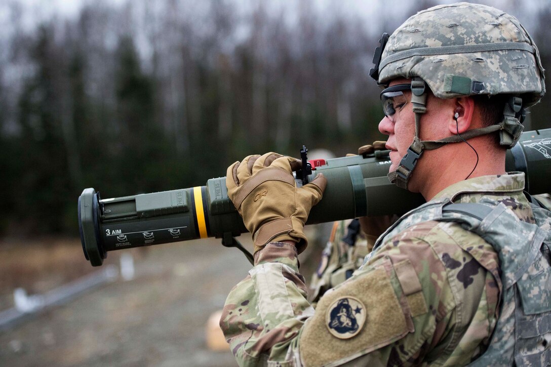 Army Spc. Chevy Yockman adjusts the rear elevation sight for a M136E1 AT4-CS light anti-armor rocket launcher.