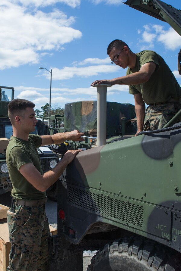 U.S. Marine Corps Pfc. Isaiah W. Rose, left, and Pfc. Carlos J. Deleon, antitank missile gunners with Battalion Landing Team 2nd Battalion, 6th Marine Regiment, upgrade a system on a high-mobility, multipurpose wheeled vehicle (HMMWV) at Camp Lejeune, N.C., Oct. 3, 2017. The Marines installed the system as part of a maintenance stand-down to fulfill maintenance requirements in preparation for a 26th MEU upcoming deployment at sea. (U.S. Marine Corps photo by Cpl. Jered T. Stone)