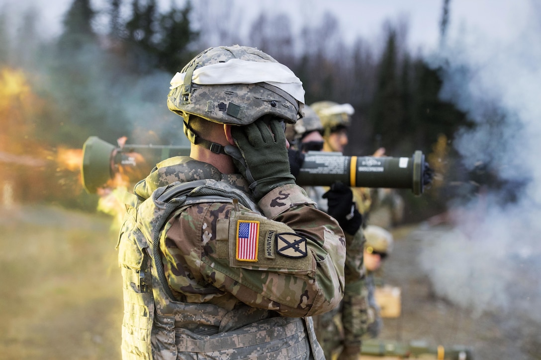 Staff Sgt. David Riley covers his ears while observing M136E1 AT4-CS light anti-armor rocket launcher live-fire.