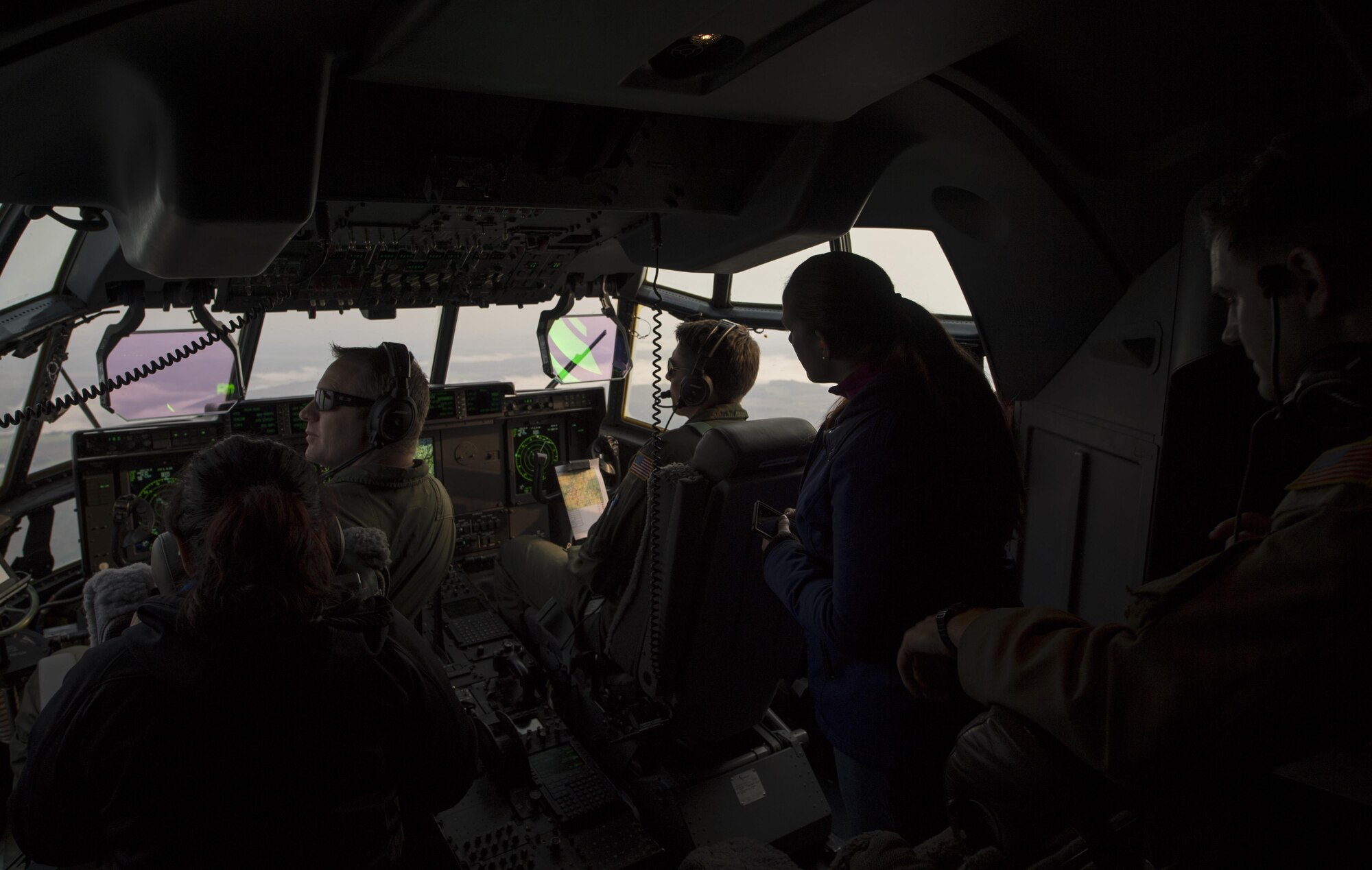 U.S. Air Force Capts. Jared Johnson (left) and Jared Reillings, both 37th Airlift Squadron pilots, fly a C-130J Super Hercules while observed by two military spouses on an incentive flight near Ramstein Air Base, Germany, Oct. 17, 2017. More than 25 spouses participated in the flight as a part of the Ramstein Airman and Family Readiness Center’s Heart Link program. (U.S. Air Force photo by Senior Airman Tryphena Mayhugh)