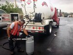 worker fills propane tank