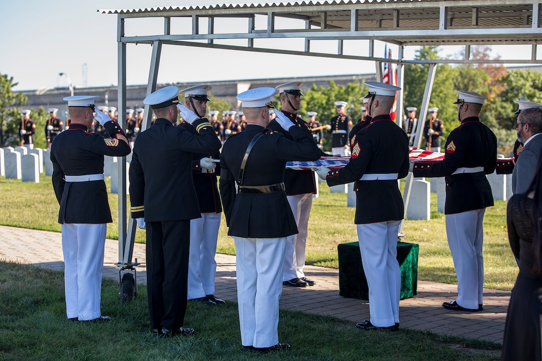 Marine Corps Body Bearers, Bravo Company, Marine Barracks Washington D.C., prepare to fold the National Ensign at the conclusion of the playing of Taps during a full honors funeral at Arlington National Cemetery, Arlington, Va., Oct. 17, 2017. Marine Barracks Washington is home to the Marines who provide support for all Marine Corps funerals and many high-ranking government officials’ funerals within the National Capitol Region. (Official U.S. Marine Corps photo by Cpl. Robert Knapp/Released)