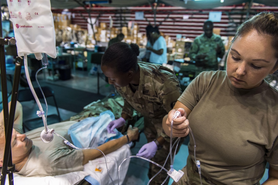 Soldier administers an IV.