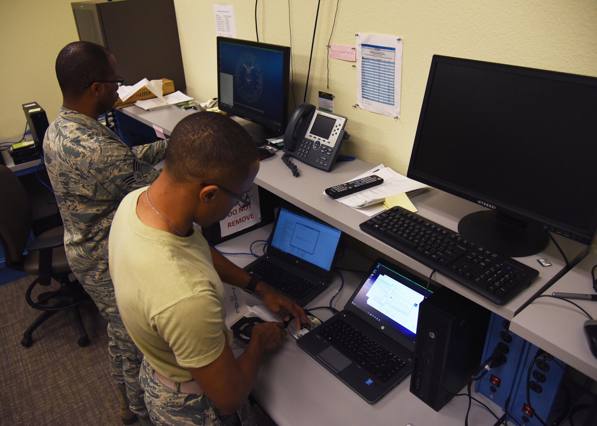 Senior Airman Jacob Tatum Jr., 403rd Communications Flight cyber transports system, and Senior Airman Treviant Evans, 403rd CF client systems technician, work on resolving a ticket that was submitted for an issue with a laptop on Oct. 14, 2017 at the Communications Building at Keesler Air Force Base, Mississippi. The 31 individuals that make up the 403rd CF, 30 of which are Airmen, are responsible for maintaining the communications systems of the units they support. (U.S. Air Force photo by Airman 1st Class Nathan Byrnes)
