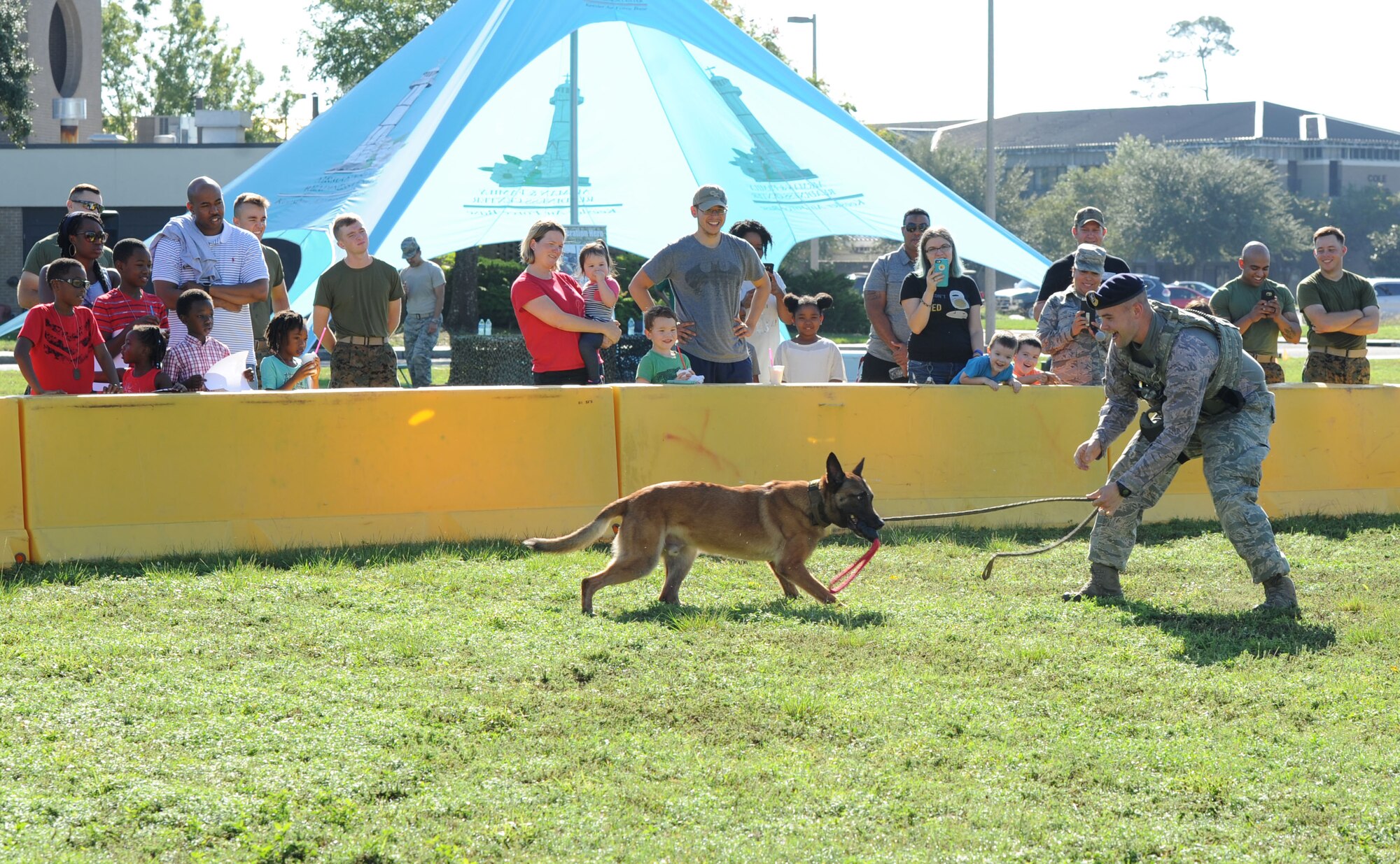 Staff Sgt. Timothy Poissant, 81st Security Forces Squadron military working dog handler, and Zeno, 81st SFS military working dog, perform a demonstration for Keesler families during Operation Hero Oct. 14, 2017, on Keesler Air Force Base, Mississippi. The event was designed to help children better understand what their parents do when they deploy. (U.S. Air Force photo by Kemberly Groue)