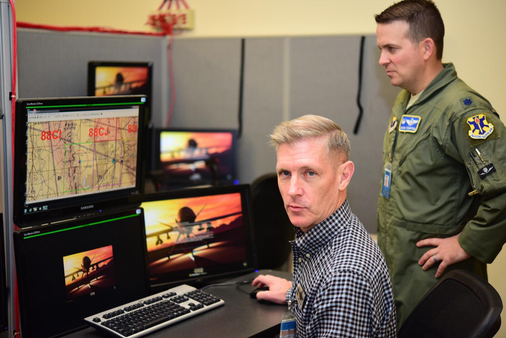 Remotely Piloted Aircraft Fundamentals Course Instructor Pilot Todd Felton of the 558th Flying Training Squadron describes the Predator Reaper Integrated Mission Environment simulator Oct. 13, 2017 at Joint Base San Antonio-Randolph as Lt. Col. Jason Thompson, 558th FTS commander listens.  PRIME allows RPA pilots and sensor operators to train together ahead of their training on a major weapon system.  (U.S. Air Force photo by Randy Martin)