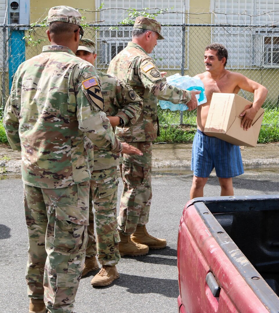 Members of the Puerto Rico Army National Guard, Reserve and active duty, along with Lt. Gen. Jeffrey Buchanan, U.S. Army North commander; Brig. Gen. José Reyes, Dual Status commander; and Caguas Mayor Hon. William Miranda Torres, distributed food and water to residents of the neighborhood Borinquen, Oct. 14. Reyes, Buchanan and Marín handed over provisions to the people who were grateful for the help received and were seriously affected by Hurricane Maria.