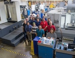 Members of the 502nd Trainer Development Squadron gather for a group photo in Hangar 74, Oct. 13, Joint Base San Antonio-Randolph, Texas. They worked with several contractors to design, test, accept, deliver and maintain 16 flight simulators that the 558th Flying Training Squadron uses to train Remotely Piloted Aircraft pilots. (U.S. Air Force photo by Tech. Sgt. Ave I. Young)