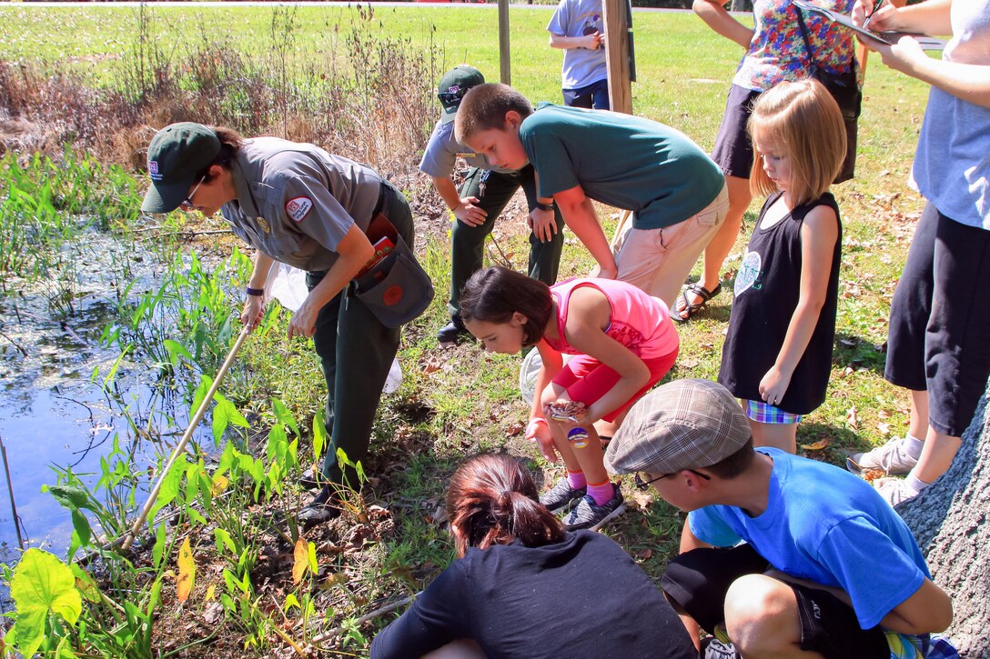 Caesar Creek Lake Ranger Kim Baker explores pond life while the citizen scientists record identified species.