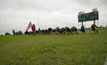 Participants in a ruck march challenge bear crawl on a sports field at Laughlin Air Force Base, Texas, Oct. 14, 2017.  The march itself started once the 23-person group finished a series of team-building exercises consisting of low crawls, crowd surfing, and bear crawls.  (U.S. Air Force photo\Airman 1st Class Daniel Hambor)