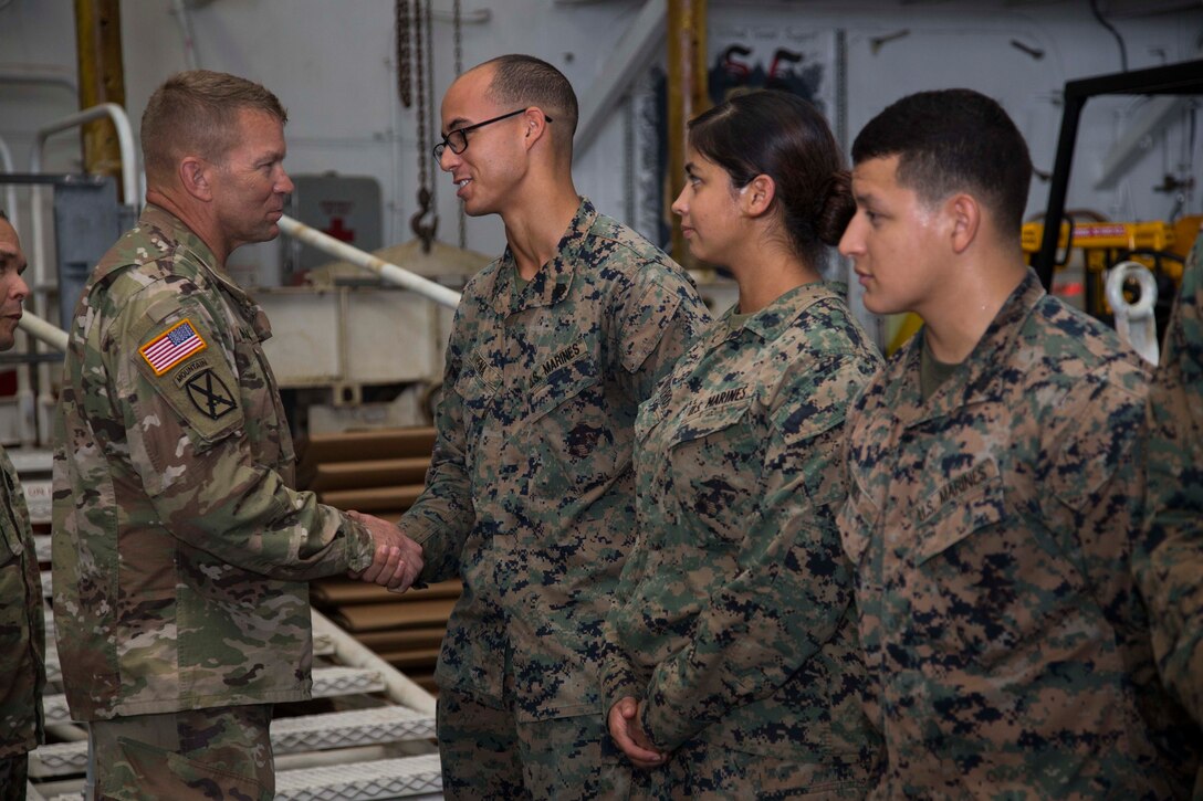 U.S. Army Lt. Gen. Jeffrey Buchanan, left, the Commander of U.S. Army North, congratulates U.S. Marines on their performance and contribution while assisting the federal and local government in hurricane relief to Puerto Rico aboard the amphibious assault ship USS Kearsarge (LHD 3) in the Caribbean Sea, Oct. 14, 2017.