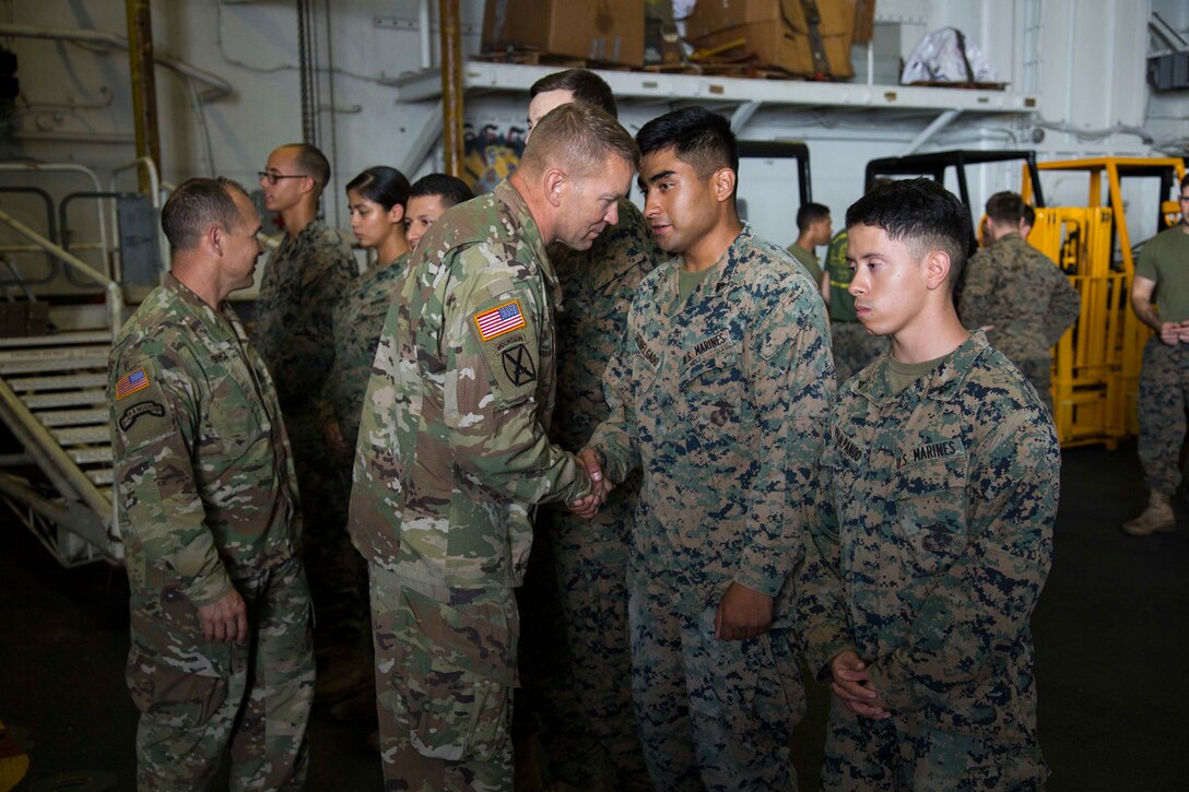 U.S. Army Lt. Gen. Jeffrey Buchanan, left, the Commander of U.S. Army North, congratulates U.S. Marines on their performance and contribution while assisting the federal and local government in hurricane relief to Puerto Rico aboard the amphibious assault ship USS Kearsarge (LHD 3) in the Caribbean Sea, Oct. 14, 2017.