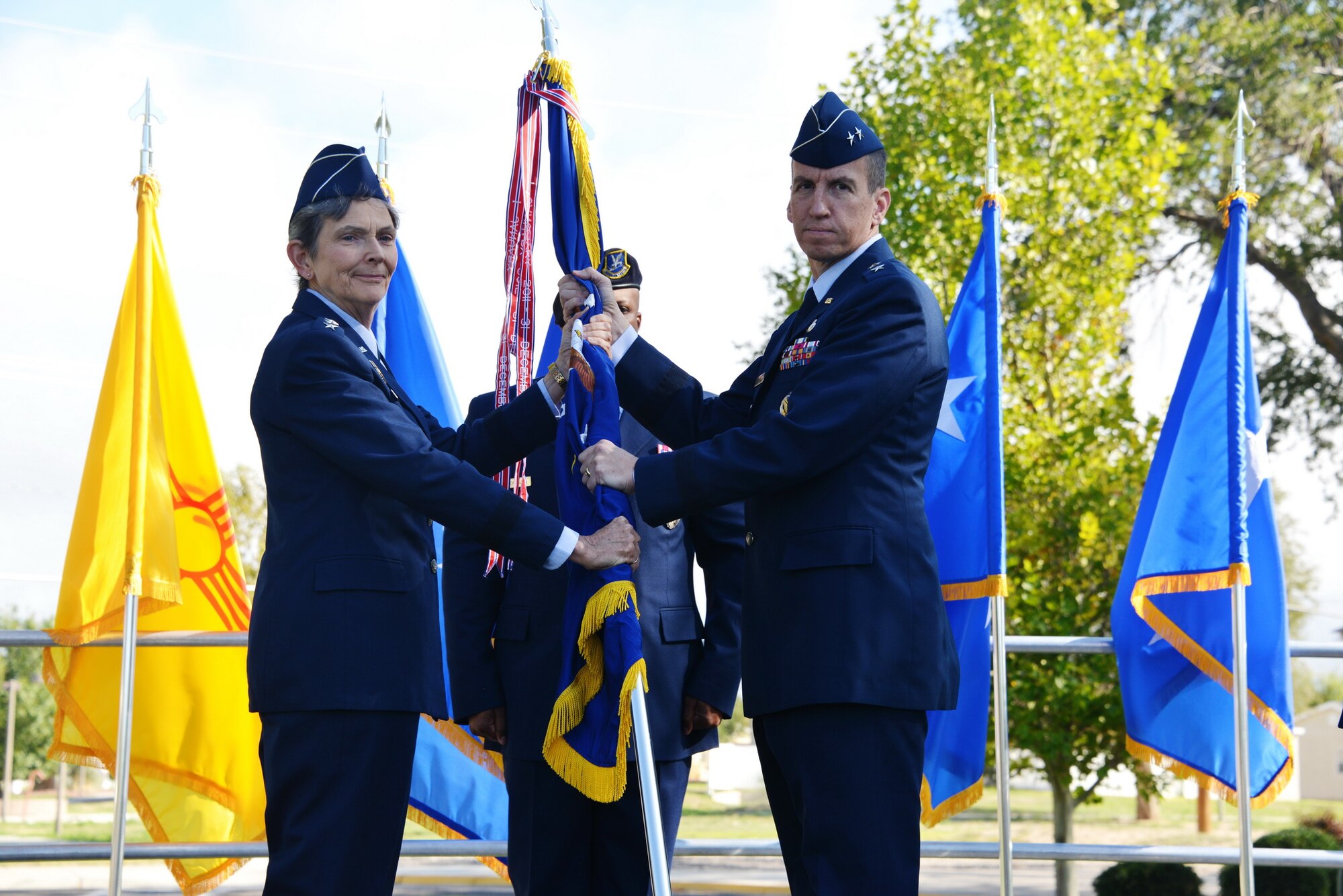 Air Force Materiel Command Commander Gen. Ellen M. Pawlikowski, passes the unit guidon to the new Air Force Nuclear Weapons Center commander Maj. Gen. Shaun Q. Morris during a change of command ceremony Oct. 6 at Hardin Field.