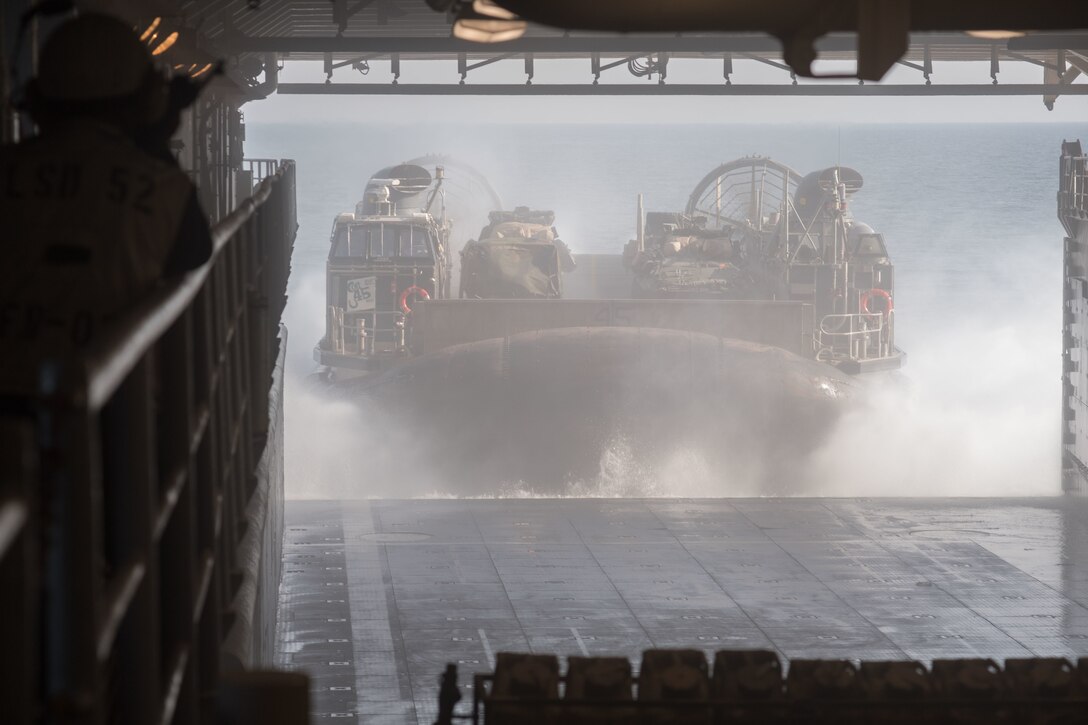 A landing craft, air cushion, operated by Sailors of Assault Craft Unit 5, exits the well deck of the amphibious dock landing ship USS Pearl Harbor as it prepares to go ashore in support of Iron Magic 18. Iron Magic 18 is a combined-arms live-fire engagement meant to expand levels of cooperation, enhance mutual maritime capabilities, and promote long-term regional stability and interoperability between U.S. forces and regional partners.