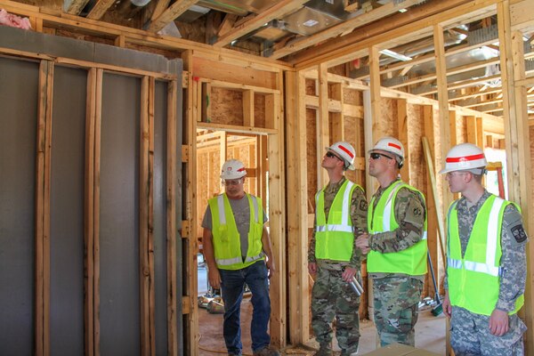 Project Engineer explains the importance of the reinforced metal between the studs during a site tour.