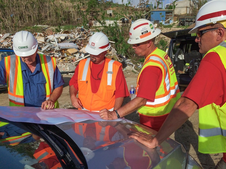 USACE Debris Team members Duane Pfouts, Chad Potts and Dennis Norman discuss operations with Kerry Kennedy, lead contractor, at the debris transfer site on St. John, USVI.