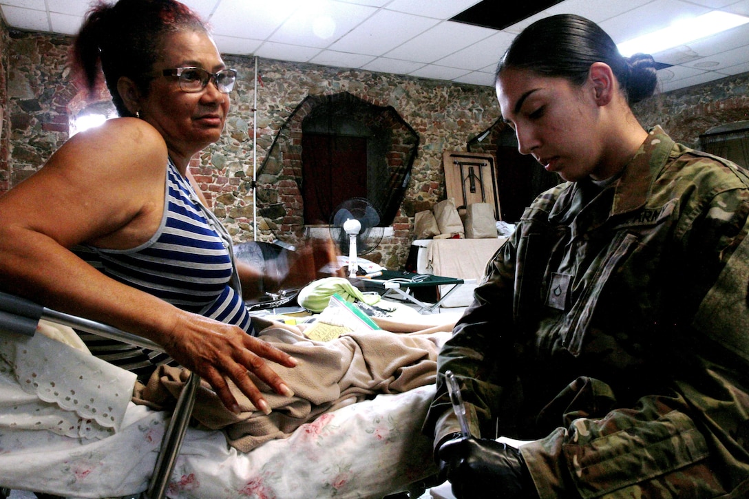 National Guardsman provides medical assistance to resident of St. Thomas, U.S. Virgin Islands.