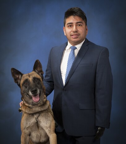 Marco Robledo, a disabled combat veteran and federal employee working at Naval Surface Warfare Center, Carderock in West Bethesda, Md., Oct. 12, 2017, poses with his service dog, Chuck Diesel. Robledo was wounded by an improvised explosive device while deployed to Iraq as a combat engineer with the National Guard in 2007. After he rehabilitated from his injuries, he followed a mentor's advice and applied to work at Carderock as a contract specialist. He spoke about being grateful for his fellow Soldiers who saved his life and for overcoming his challenges and making a good life for himself following his upbringing by struggling migrant workers. (U.S. Navy photo by Devin Pisner/Released)