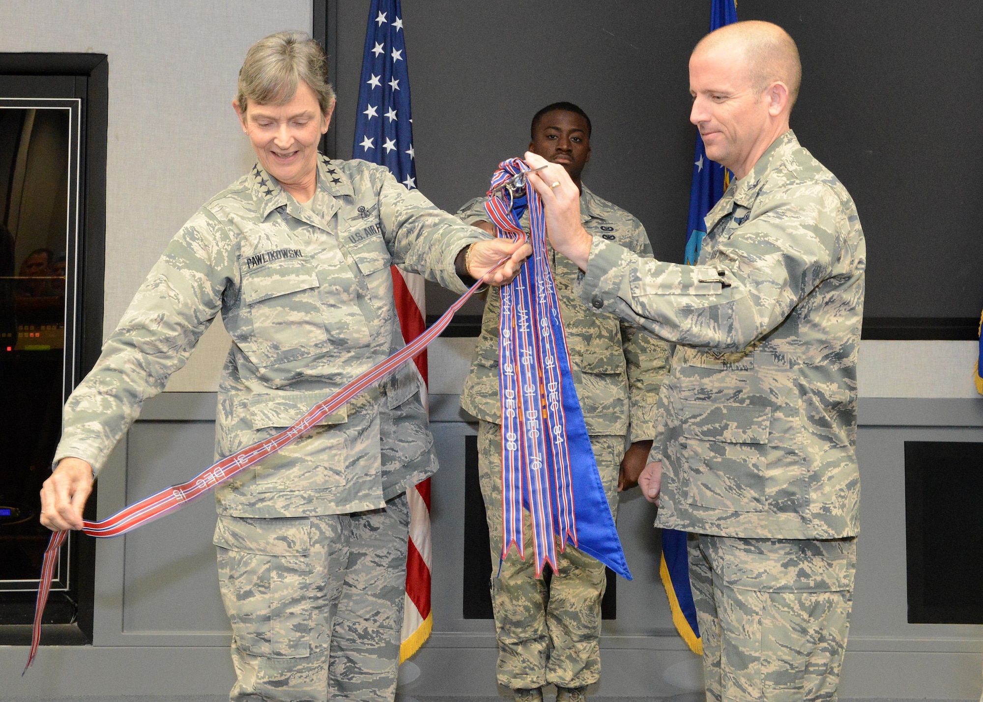 Gen. Ellen Pawlikowski, commander of Air Force Materiel Command, placed a new award streamer on the U.S. Air Force Test Pilot School guidon Oct. 12 with the assistance of Col. Matthew Higer, U.S.A.F. TPS commandant. The streamer is for TPS winning the Air Force Organizational Excellence Award recently. (U.S. Air Force photo by Kenji Thuloweit)