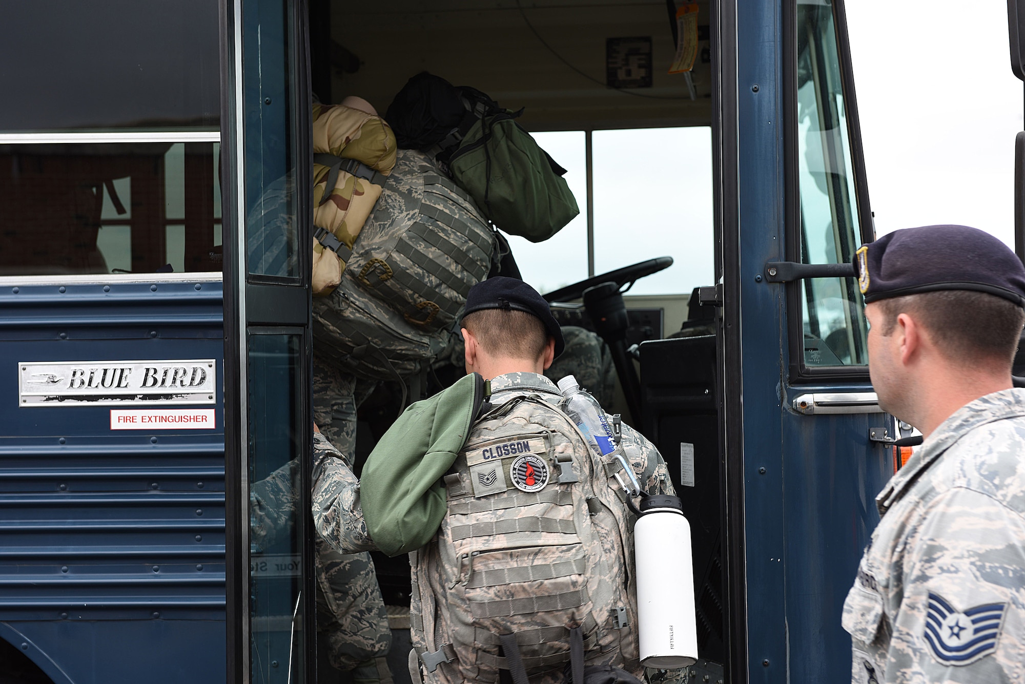 Tech. Sgt. Closson wearing a backpack boards an Air Force bus