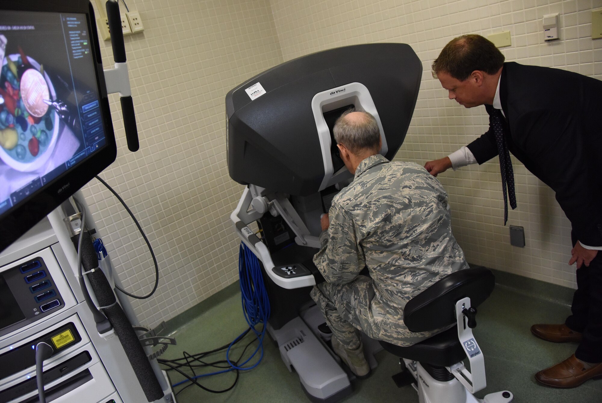 Blaise Provitola, Intuitive Surgical Inc. area sales manager, guides Lt. Gen. Mark Ediger, Air Force Surgeon General, as he operates a da Vinci surgical system, which is used for robotics surgeries, during a visit to the clinical research laboratory Oct. 17, 2017, on Keesler Air Force Base, Mississippi. The purpose of Ediger’s visit was to get familiar with the 81st Medical Group’s mission, operations and personnel. During his tour, he visited more than 10 different units in the 81st MDG to include mammography, emergency department, radiology and oncology, genetics and the clinical research laboratory. (U.S. Air Force photo by Kemberly Groue)