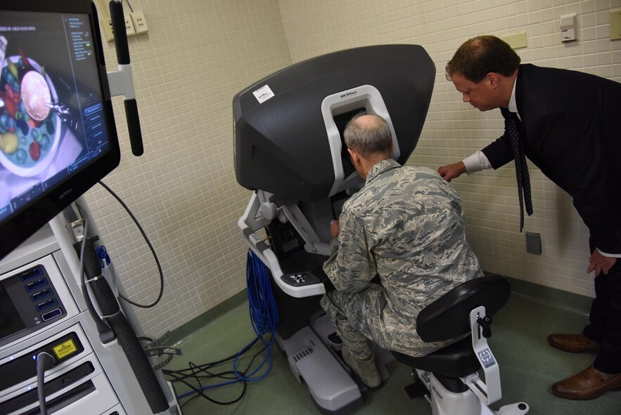 Blaise Provitola, Intuitive Surgical Inc. area sales manager, guides Lt. Gen. Mark Ediger, Air Force Surgeon General, as he operates a da Vinci surgical system, which is used for robotics surgeries, during a visit to the clinical research laboratory Oct. 17, 2017, on Keesler Air Force Base, Mississippi. The purpose of Ediger’s visit was to get familiar with the 81st Medical Group’s mission, operations and personnel. During his tour, he visited more than 10 different units in the 81st MDG to include mammography, emergency department, radiology and oncology, genetics and the clinical research laboratory. (U.S. Air Force photo by Kemberly Groue)