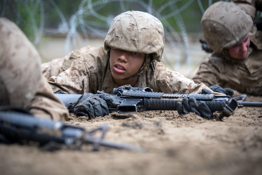 A recruit crawls through the dirt.