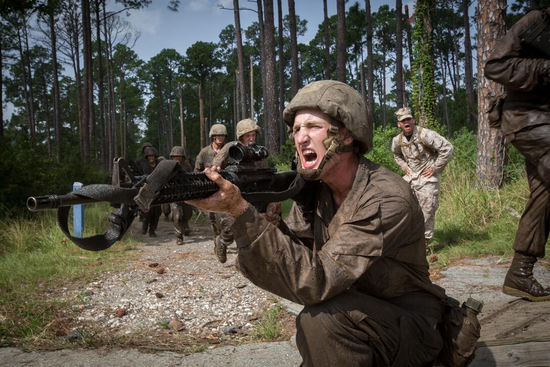 A Marine shouts out orders to a fellow Marines.