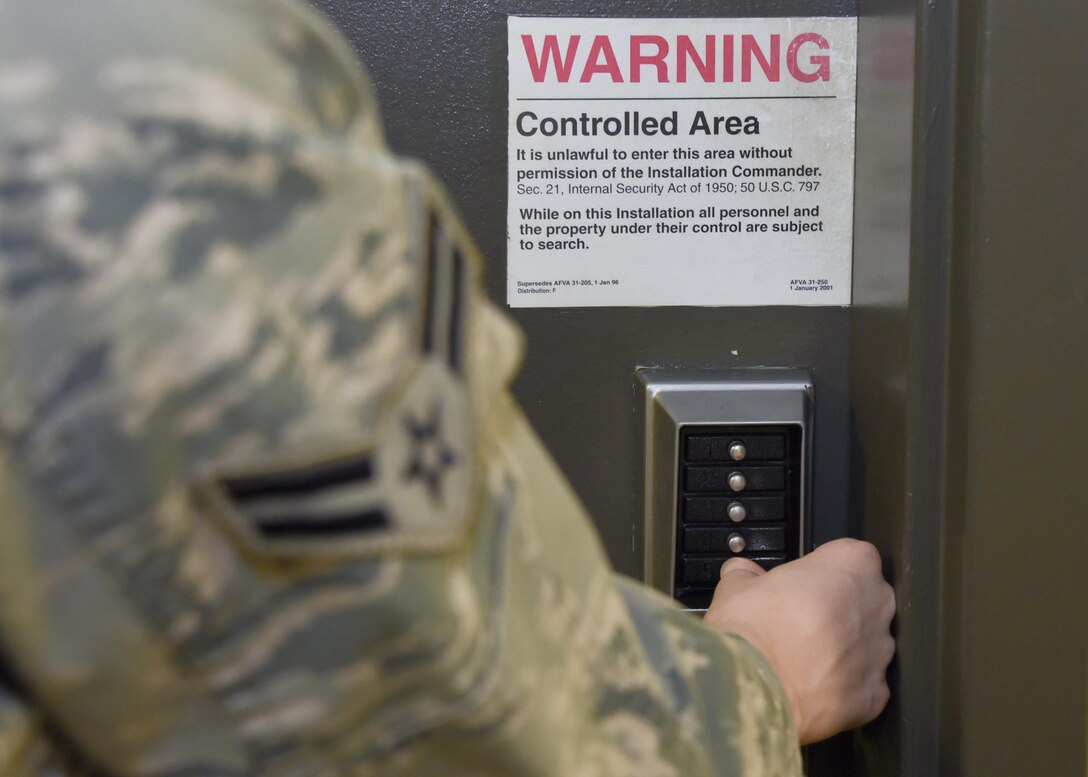 Airman 1st Class Allison Dassing enters a door to a controlled intelligence office Oct. 3, 2017 at Warfield Air National Guard, Middle River, Md. Dassing is a fulltime intelligence technician but in her free time enjoys spending time with family, travelling and video games. (U.S. Air National Guard photo by Senior Airman Enjoli Saunders)