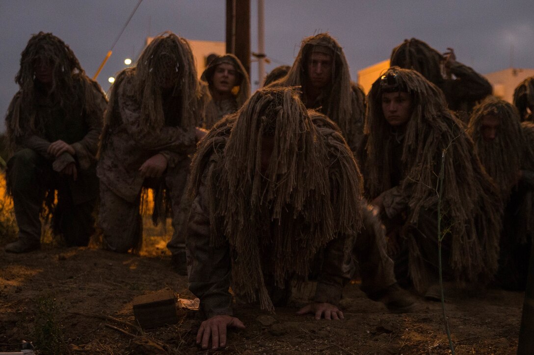 U.S. Marines with 1st Light Armored Reconnaissance Battalion (LAR), 1st Marine Division, prepare to run their ghillie suits through a mud and water exercise
