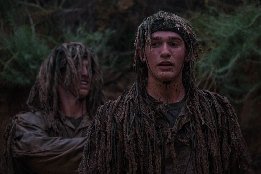 U.S. Marine Corps Pfc. Mitchell Jensen, left, and Pfc. Sean Mikul, both riflemen with 1st Light Armored Reconnaissance Battalion (LAR), 1st Marine Division, apply mud to their ghillie suits during an exercise at Marine Corps Base Camp Pendleton, Calif., Oct. 13, 2017.